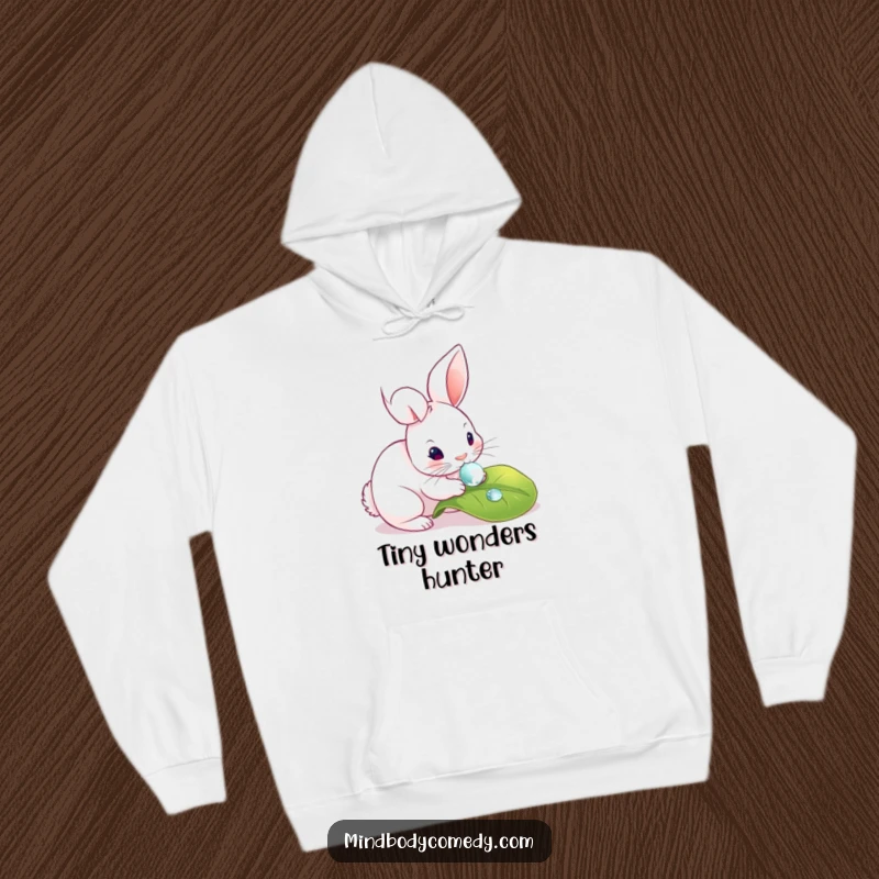 Funny hoodie with a rabbit gently touching a dewdrop on a leaf, evoking a sense of wonder and peace.